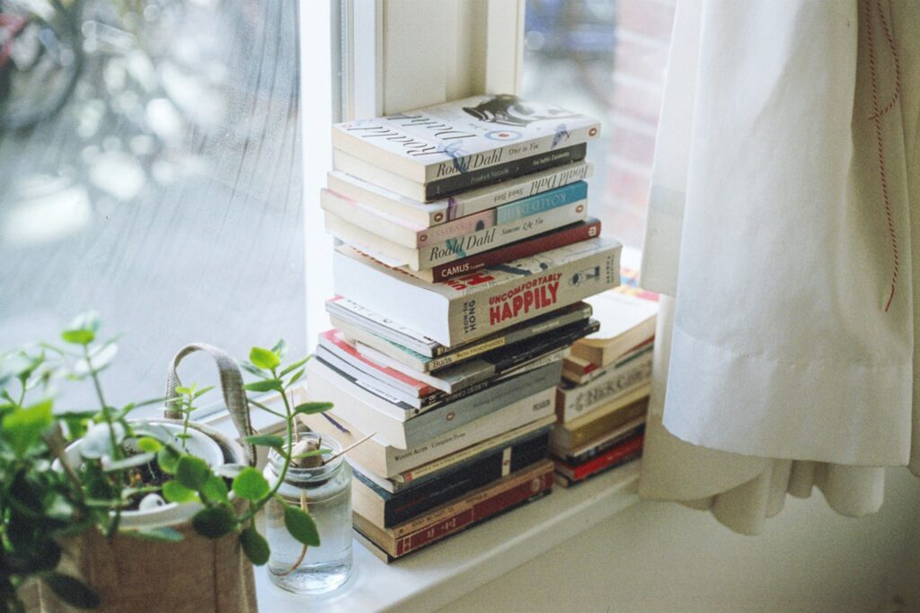Photo of a stack of books on a windowsill by Florencia Viadana on Unsplash